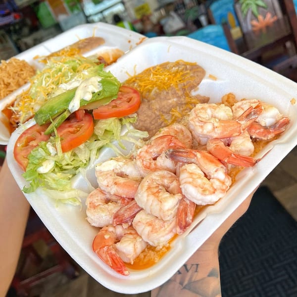 Sayulitas' Mexican shrimp plate with rice, beans, and a side salad in a to-go container.