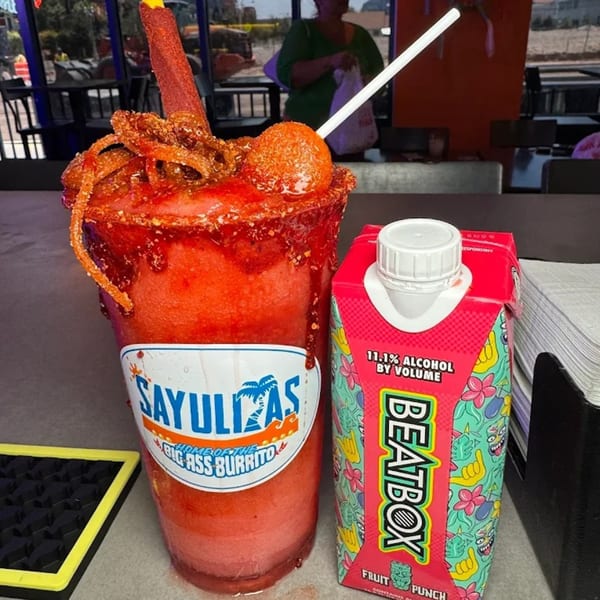 A Sayulitas branded red frozen drink with candy and a BeatBox Fruit Punch carton.