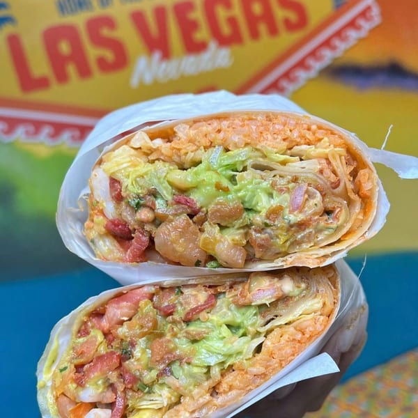 Two halves of a Sayulitas Mexican burrito, filled with rice, guacamole, and meat, against a colorful background.
